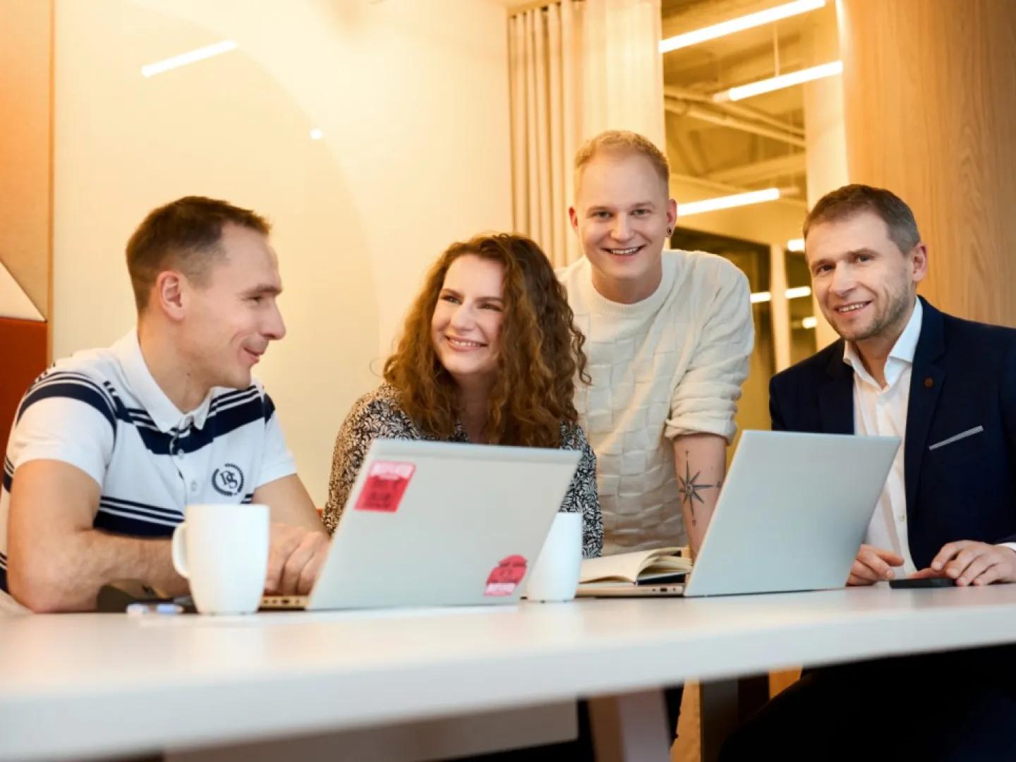 Trzech mężczyzn i kobieta przed komputerami